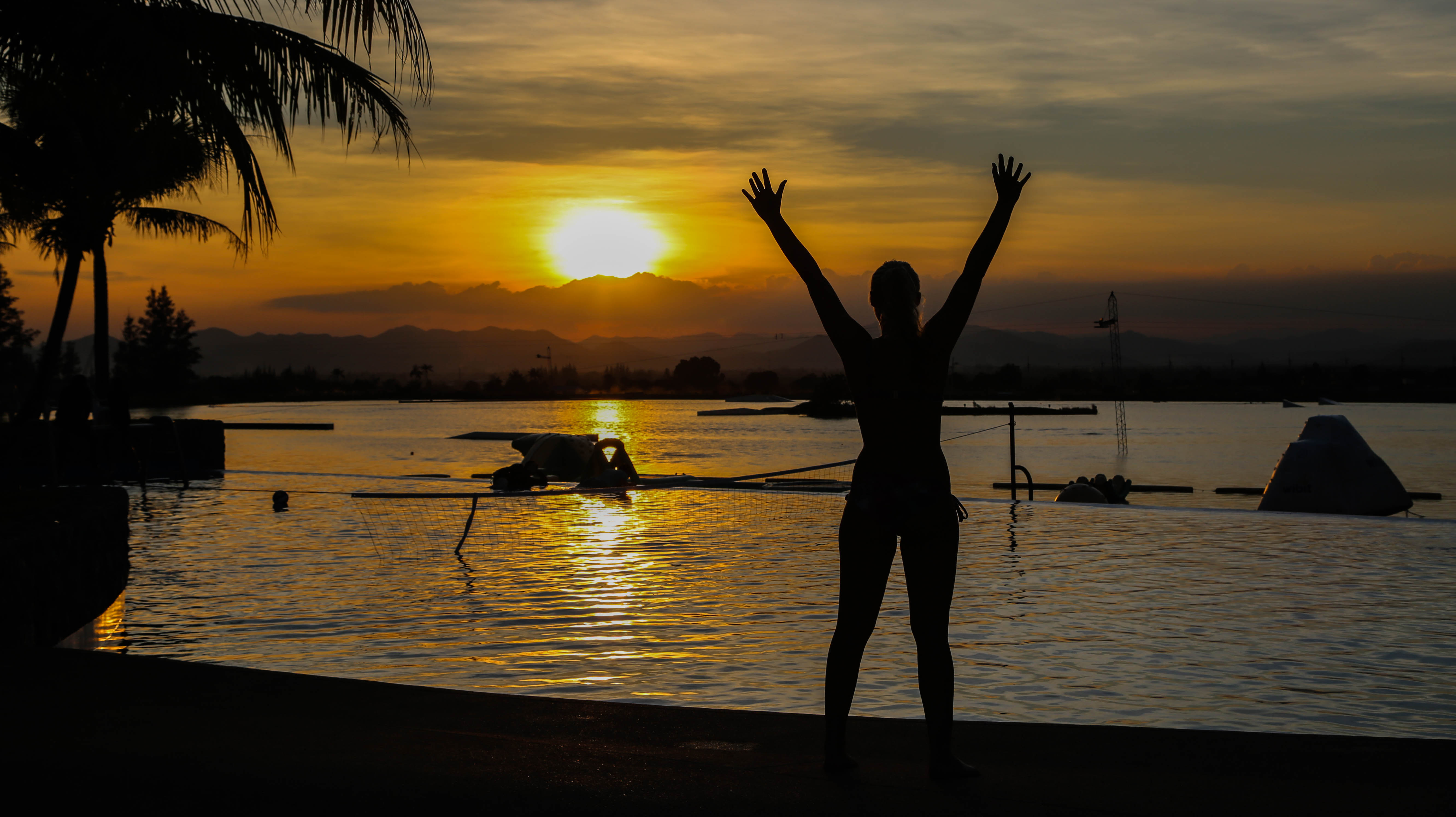 Sunset at a water park in Thailand, my daughter saying goodbye to the sun